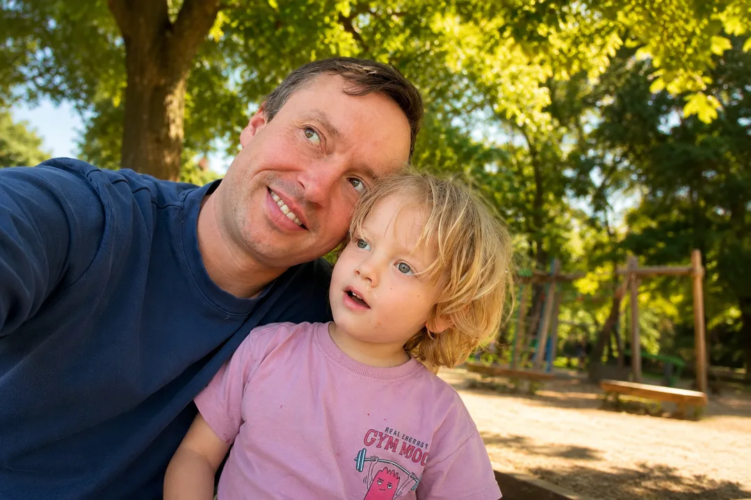 Falko and his son cheek to cheek at the playground